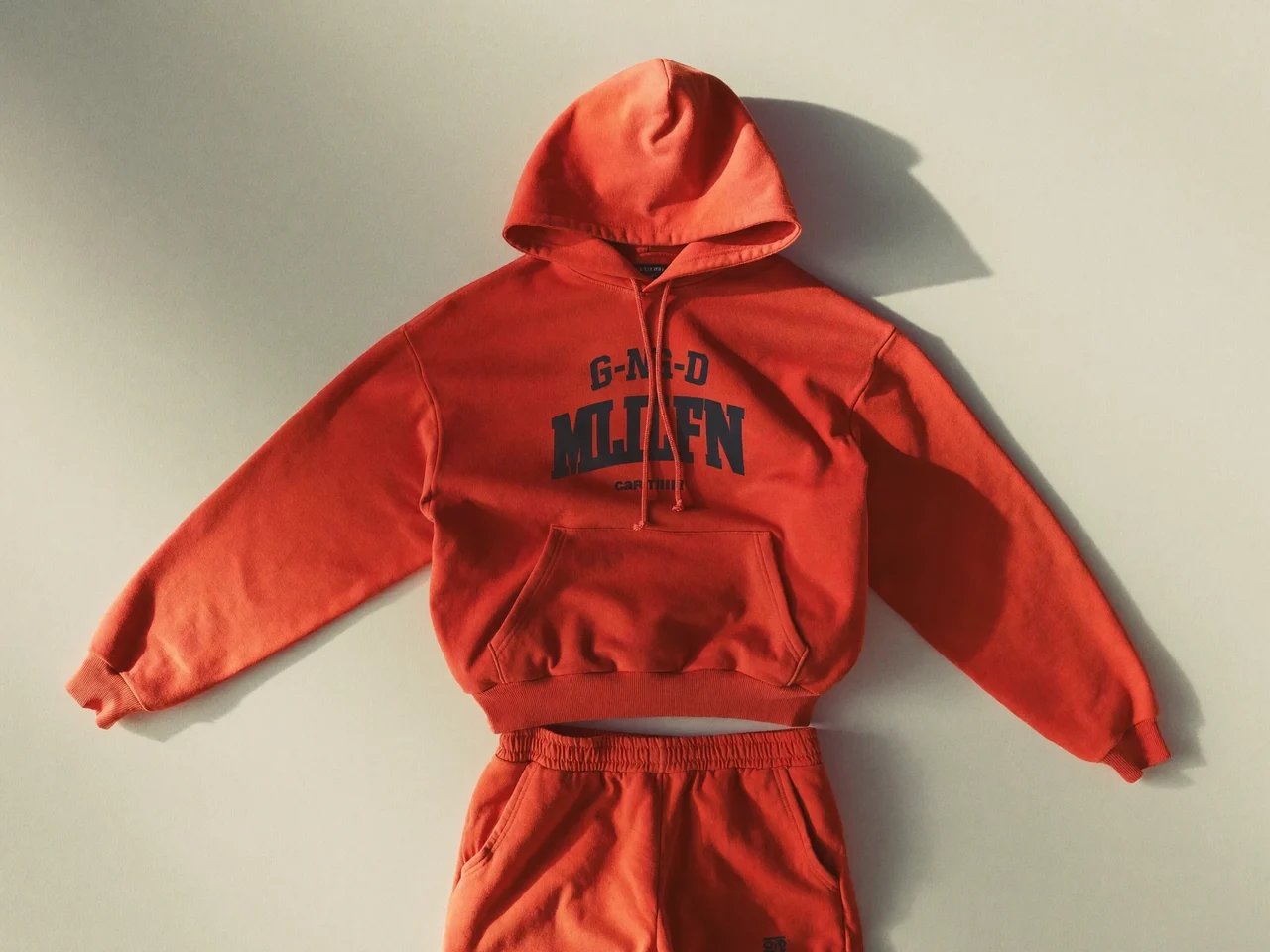 Hoodie-und-Jogger-Set in leuchtenden Farben flach auf hellem Untergrund